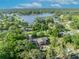 Expansive aerial view showcasing home with pool, set amidst verdant foliage and a tranquil lake backdrop at 349 Evansdale Rd, Lake Mary, FL 32746