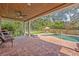 Covered patio with brick floor overlooking the backyard with the pool at 349 Evansdale Rd, Lake Mary, FL 32746