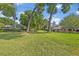 Front yard with large trees, green grass and two homes visible in the background at 349 Evansdale Rd, Lake Mary, FL 32746