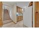 View of the kitchen adjacent to carpeted stairs, with a white refrigerator and light wood cabinets at 349 Evansdale Rd, Lake Mary, FL 32746