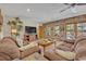 Open-concept living room with brick wall, wood accents, comfortable seating, and plenty of natural light at 349 Evansdale Rd, Lake Mary, FL 32746