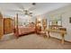 This main bedroom features a canopy bed, ceiling fan, wood furniture, and natural light to create a peaceful retreat at 349 Evansdale Rd, Lake Mary, FL 32746