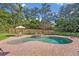 Backyard with a free-form pool surrounded by a brick patio and lush landscaping at 349 Evansdale Rd, Lake Mary, FL 32746