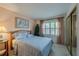 Cozy bedroom featuring a comfortable bed, large window, and mirrored closet at 4029 N Waterbridge Cir, Port Orange, FL 32129