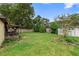 Spacious backyard with mature trees, green grass, shed, patio, and full perimeter fencing for privacy and outdoor enjoyment at 411 Columbus Ave, Orange City, FL 32763