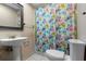Cozy bathroom with floral shower curtain, pedestal sink, and toilet at 411 Columbus Ave, Orange City, FL 32763