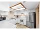 Well-lit kitchen with white cabinets, stainless steel refrigerator, and tiled floor at 411 Columbus Ave, Orange City, FL 32763