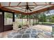 Enclosed patio area featuring comfortable furniture, ceiling fan, and an airy view of the fenced in backyard at 411 Columbus Ave, Orange City, FL 32763