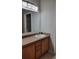 Bathroom vanity with wood cabinets, light countertop, sink, and a large framed mirror at 421 Holly Fern Trl, Deland, FL 32720