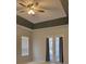 Bright bedroom featuring a tray ceiling with fan, a window, and sliding glass doors at 421 Holly Fern Trl, Deland, FL 32720