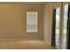 Bedroom with neutral carpet, a window, and a glass door to the backyard at 421 Holly Fern Trl, Deland, FL 32720