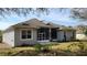 Back exterior of home with screened patio, skylight and manicured lawn at 421 Holly Fern Trl, Deland, FL 32720