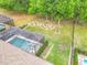 Aerial view of the backyard featuring a screened in pool and spa, lovely landscaping and surrounding mature trees at 425 Wedgeworth Ln, Deland, FL 32724