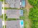 An aerial view showcasing the backyard with screened in pool and spa, surrounded by well-maintained landscaping and mature trees at 425 Wedgeworth Ln, Deland, FL 32724