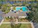 Aerial view showcases a community pool area with palm trees, seating and lounge chairs, and lush landscaping at 425 Wedgeworth Ln, Deland, FL 32724