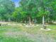Serene backyard with mature trees, flowering garden, decorative rocks, and a bird bath at 425 Wedgeworth Ln, Deland, FL 32724