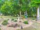 Well maintained backyard garden featuring mature trees, vibrant plants, decorative rocks, and a bird bath centerpiece at 425 Wedgeworth Ln, Deland, FL 32724