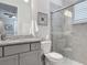 Bathroom features a gray vanity with granite countertop, decorative mirror and glass enclosed shower at 425 Wedgeworth Ln, Deland, FL 32724