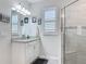 Bathroom boasts a single sink vanity with granite countertops and a glass shower with gray tiling at 425 Wedgeworth Ln, Deland, FL 32724