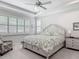 Bright bedroom featuring a floral bedspread, ceiling fan, and multiple windows with plantation shutters at 425 Wedgeworth Ln, Deland, FL 32724