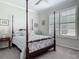 Bedroom featuring a classic four-poster bed with patterned bedding and a window with shutters at 425 Wedgeworth Ln, Deland, FL 32724