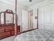 Bedroom with a four-poster bed, a dresser with a mirror, and a doorway to another room at 425 Wedgeworth Ln, Deland, FL 32724