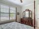 Bedroom with a four-poster bed, a dresser, and a window with plantation shutters at 425 Wedgeworth Ln, Deland, FL 32724