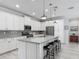 Modern kitchen featuring white cabinets, stainless steel appliances, and a granite island with seating at 425 Wedgeworth Ln, Deland, FL 32724