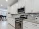 Modern kitchen with stainless steel appliances, granite counters, and ample storage at 425 Wedgeworth Ln, Deland, FL 32724