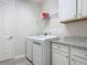 Clean laundry room featuring a washer and dryer with overhead shelving and a countertop at 425 Wedgeworth Ln, Deland, FL 32724