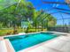 Sparkling screened-in pool with a hot tub and a basketball hoop, set against a lush green backdrop at 425 Wedgeworth Ln, Deland, FL 32724