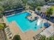 Aerial view of community pool with a splash pad, lounge seating and a nearby building at 425 Wedgeworth Ln, Deland, FL 32724