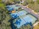 Aerial view of well-maintained tennis courts surrounded by trees and a parking area at 425 Wedgeworth Ln, Deland, FL 32724