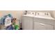 Close-up of a white washer and dryer with laundry supplies on a wire rack at 4273 Ne 29Th Pl, Ocala, FL 34470