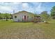 Charming home featuring a wooden deck, a well-manicured lawn, and a vibrant red door at 430 S Woodward Ave, Deland, FL 32720