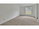 Carpeted bedroom with a bright window offers a simple and clean space at 430 S Woodward Ave, Deland, FL 32720