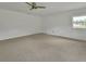 Spacious bedroom with neutral carpet, white walls, and a ceiling fan at 430 S Woodward Ave, Deland, FL 32720