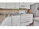 Close-up of white kitchen cabinets and appliances with granite counters at 430 S Woodward Ave, Deland, FL 32720