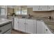 Detailed view of a kitchen featuring granite counters and white cabinetry at 430 S Woodward Ave, Deland, FL 32720