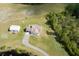 Aerial view featuring a home, a separate garage, a pond, and surrounded by green landscape at 4503 Colony Rd, New Smyrna Beach, FL 32168