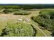 Expansive aerial view features a home with separate garage, pond, surrounded by green landscape at 4503 Colony Rd, New Smyrna Beach, FL 32168