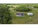 Property featuring a home with a dark roof, shed, green grass and tree coverage at 4503 Colony Rd, New Smyrna Beach, FL 32168