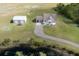 Aerial shot of property featuring a home, separate garage, pond and long curving driveway at 4503 Colony Rd, New Smyrna Beach, FL 32168