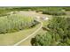 Expansive aerial view of the property highlighting its long driveway, separate shed, pond, and natural surroundings at 4503 Colony Rd, New Smyrna Beach, FL 32168