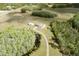 Aerial view showcasing a home with long driveway, separate garage, pond and green landscape at 4503 Colony Rd, New Smyrna Beach, FL 32168