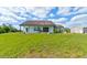 Back exterior view features a sprawling green yard and white home with a covered porch at 4503 Colony Rd, New Smyrna Beach, FL 32168