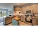 Bright kitchen featuring wooden cabinets, granite countertops, stainless steel appliances, and backyard views at 4503 Colony Rd, New Smyrna Beach, FL 32168