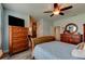 Cozy main bedroom featuring hardwood floors, light blue walls, a ceiling fan, and traditional wooden furniture at 4503 Colony Rd, New Smyrna Beach, FL 32168