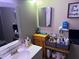 Bathroom with a vanity, mirror, and organized toiletries on wooden shelving at 4555 Tower Pine Rd # Ge, Orlando, FL 32839