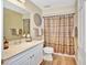Well-maintained bathroom featuring white cabinets, a large mirror, and a shower with stylish curtain at 4670 Links Village Dr # B102, Ponce Inlet, FL 32127
